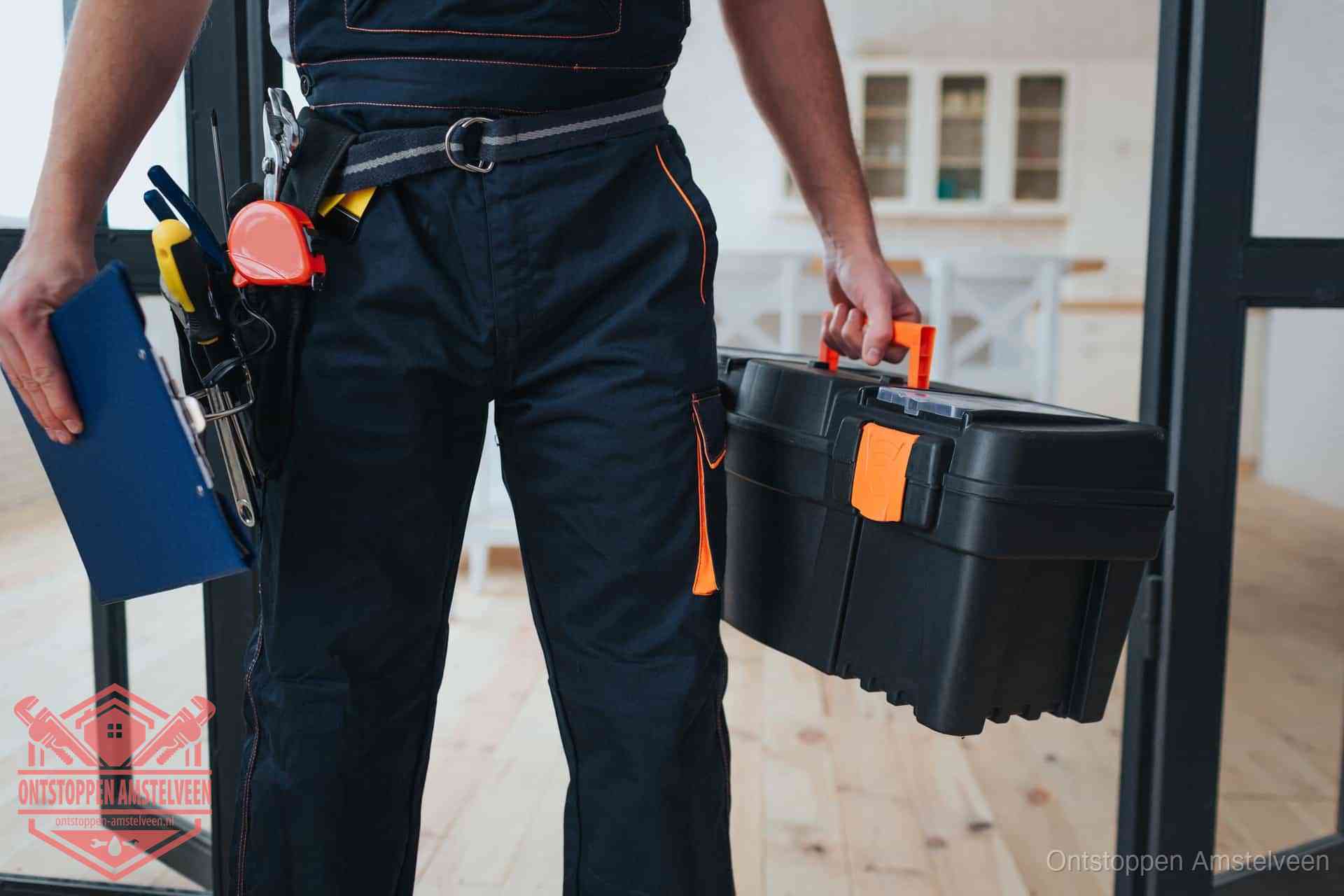Een monteur met gereedschapsriem en klembord in een keuken, klaar om een transparante prijs voor het gootsteen ontstoppen in Amstelveen te geven