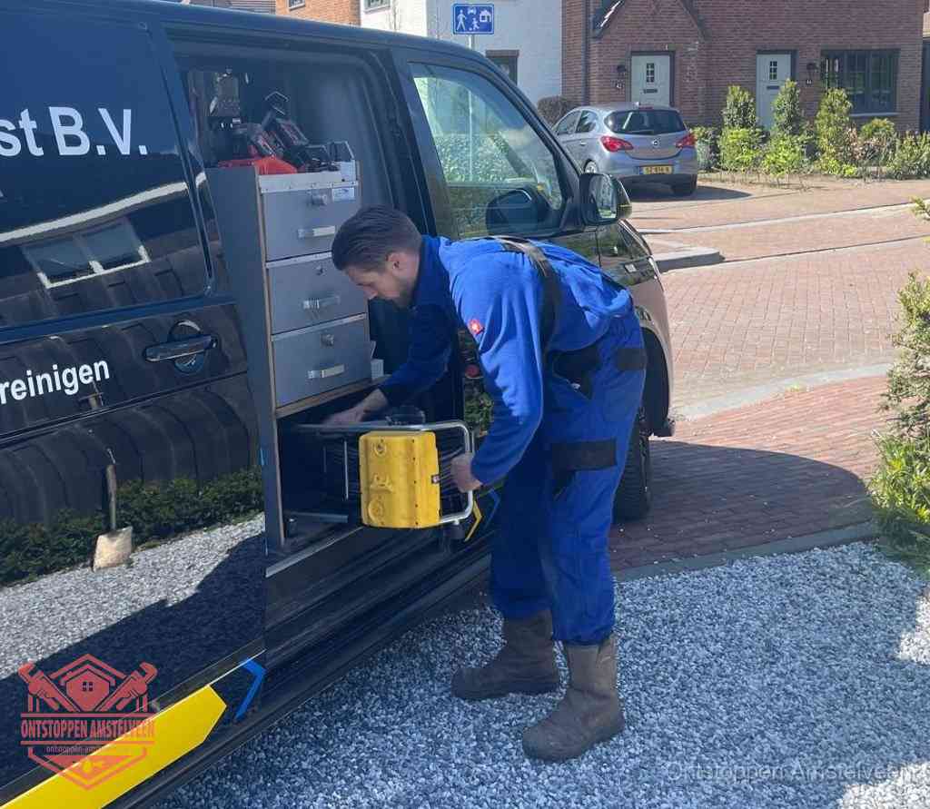 Een monteur pakt apparatuur uit de bedrijfsbus voor service aan huis, het moment om een professional in te schakelen voor een verstopte wc in Amstelveen