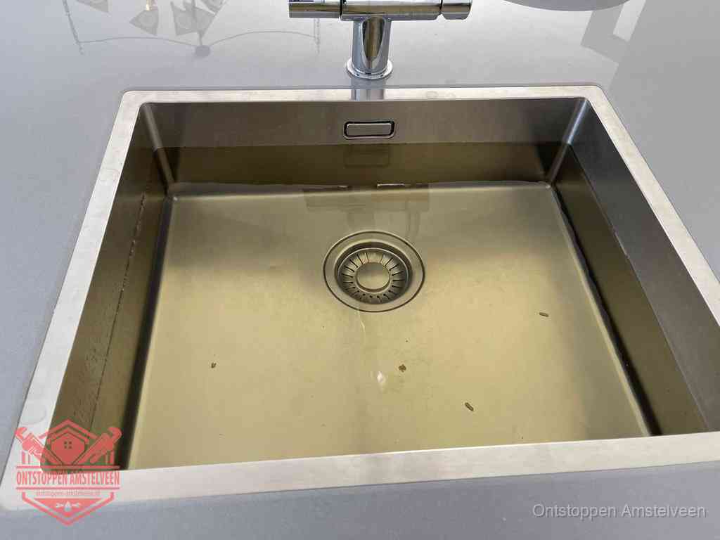 Stilstaand water in een rvs spoelbak dat niet wegloopt, een duidelijk signaal van een gootsteenverstopping in Amstelveen