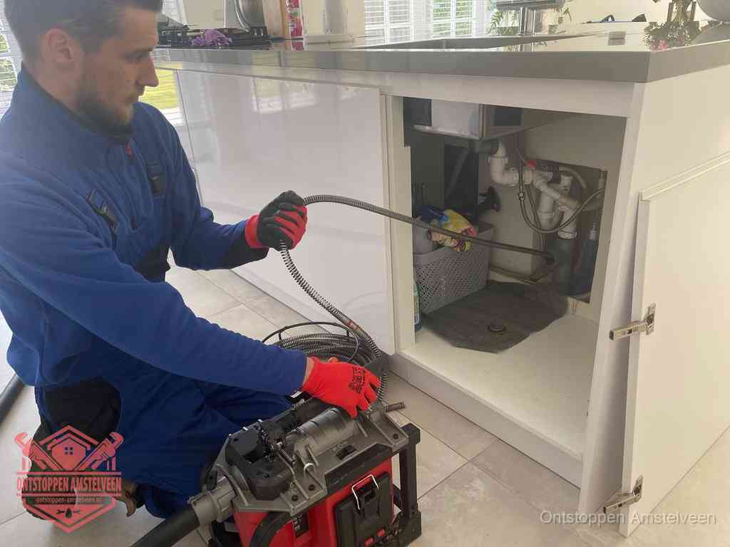 Een monteur reinigt de keukenafvoer grondig met een veermachine om terugkerende gootsteenverstoppingen te voorkomen in Amstelveen